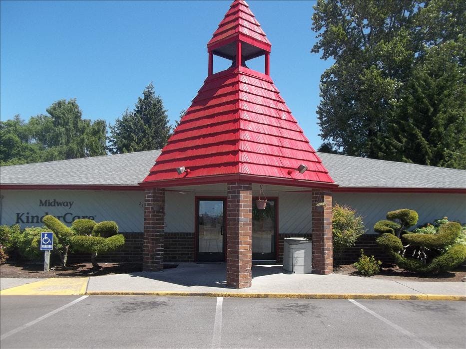 Entrance to a building with a tall red pointed roof above double doors