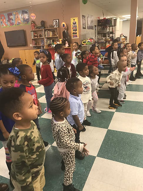 Group of children standing in a classroom