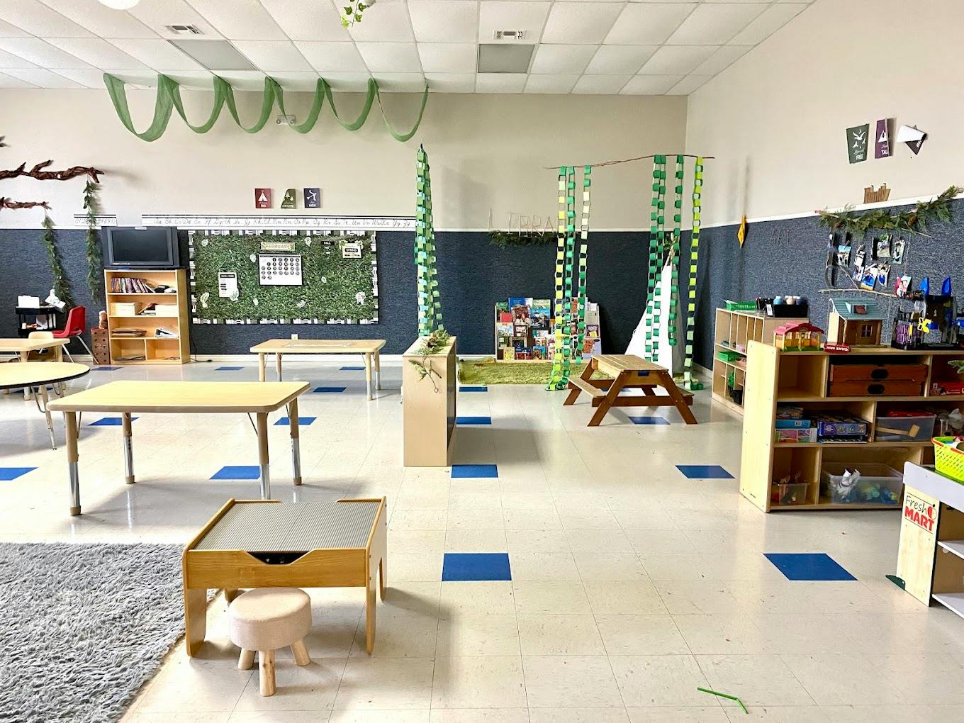Classroom interior with small wooden furniture and play areas