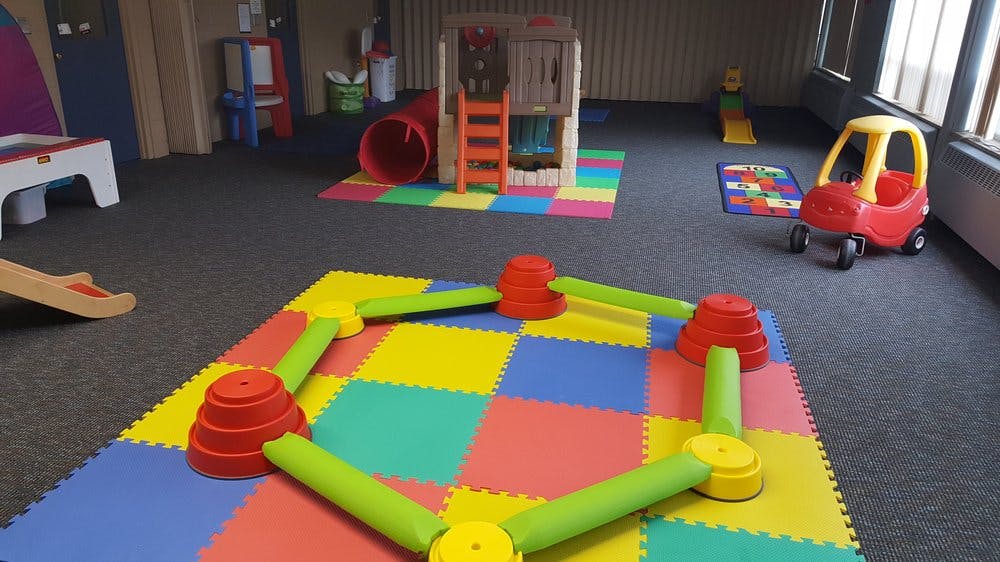 Playroom with colorful mats and various play equipment