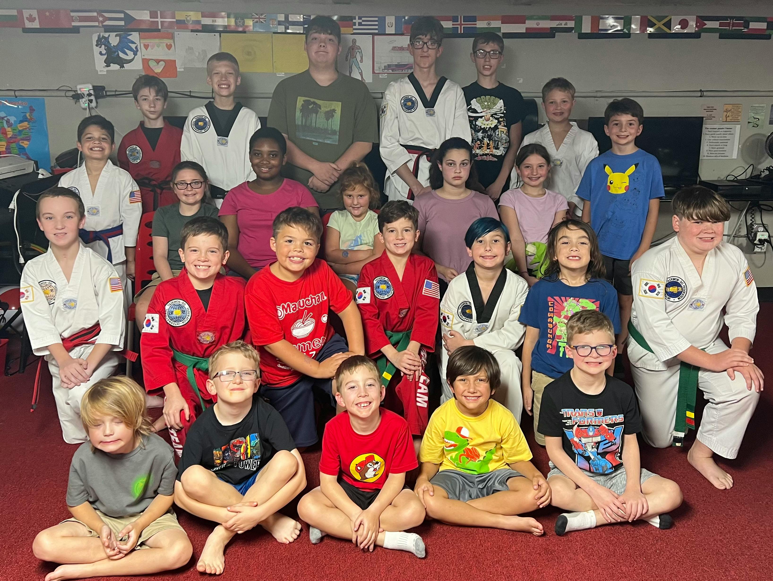 Group of people and children in martial arts uniforms posing for a photo