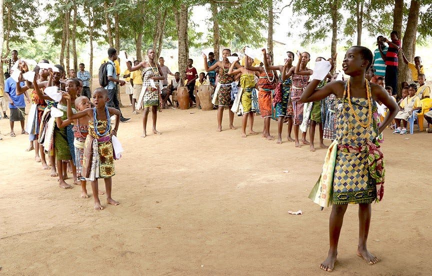 Children in traditional attire performing outdoors