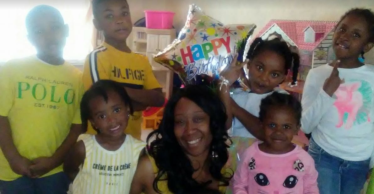Person with multiple children and a Happy Birthday balloon