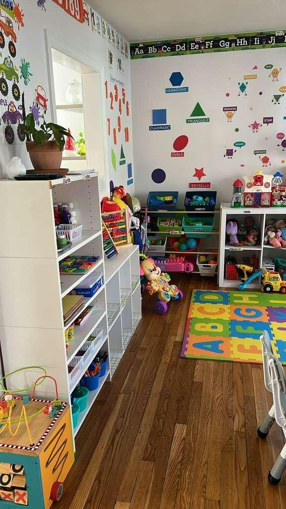 Classroom interior with alphabet and shape wall decals, shelves, and toys