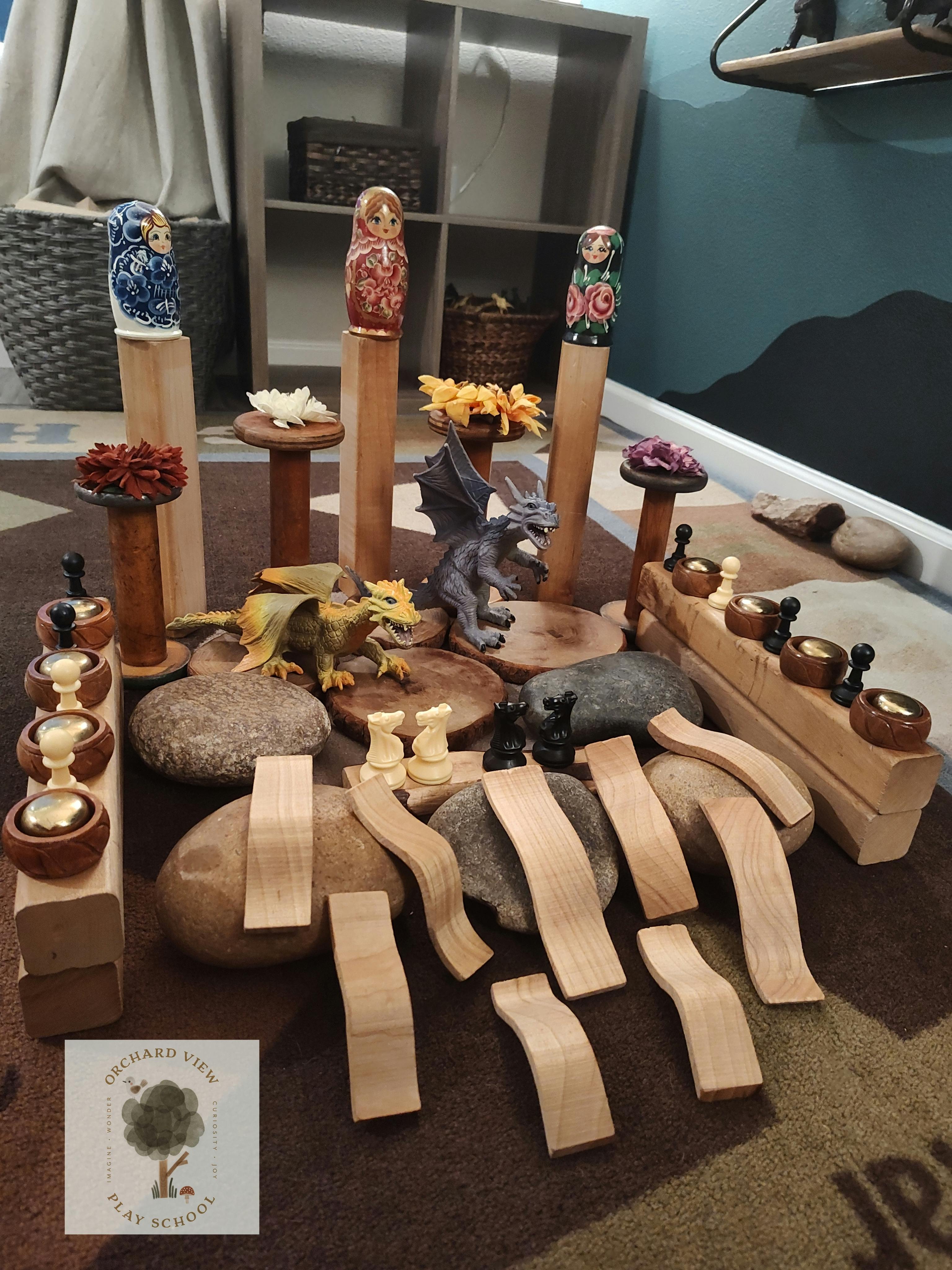Wooden blocks, rocks, and figurines arranged on a rug