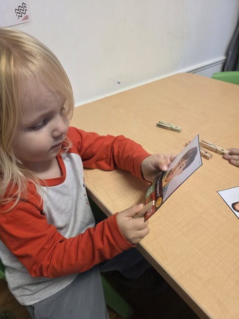 Child holding a card with a person's face on it