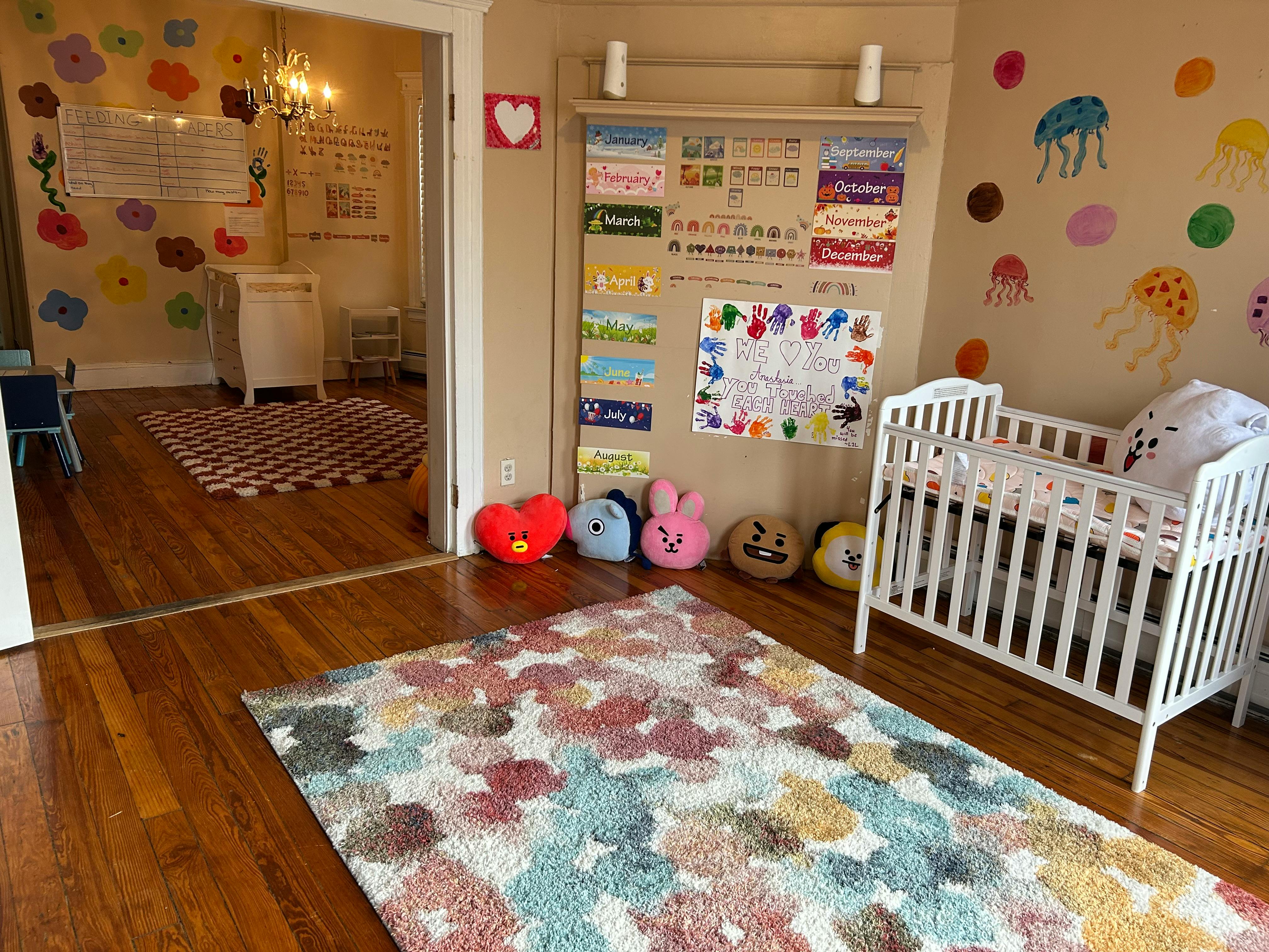 Nursery room with a white crib, colorful rug, and wall decorations