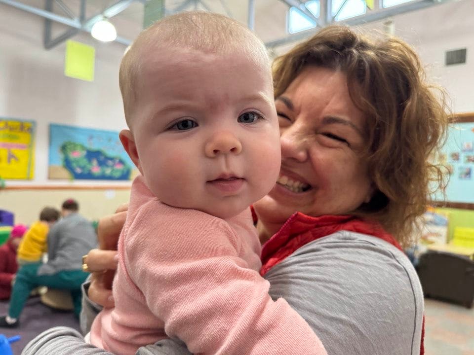 Person holding a child in a child in a classroom