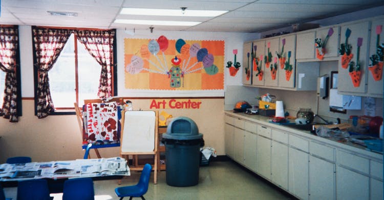 Classroom with art supplies, cabinets, and a sign that reads "Art Center"