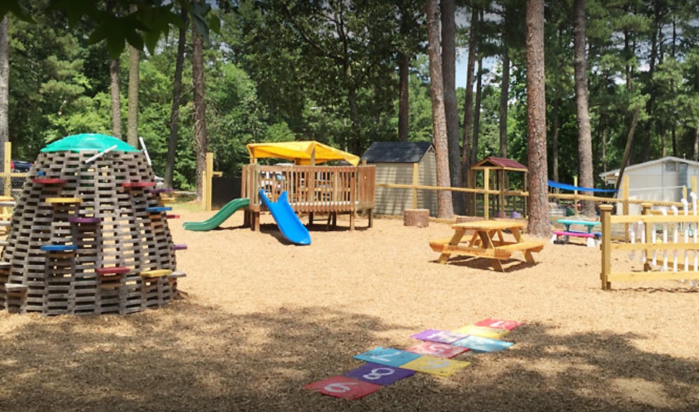 Outdoor playground with climbing structure, slides, and picnic table