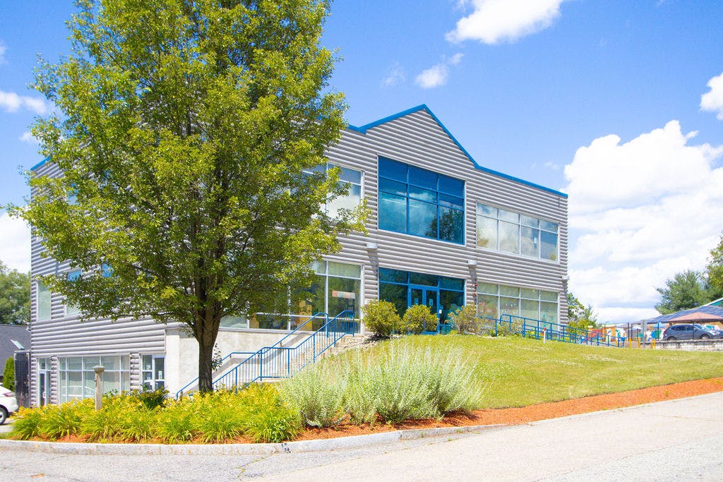 Modern building with large windows and a tree in front