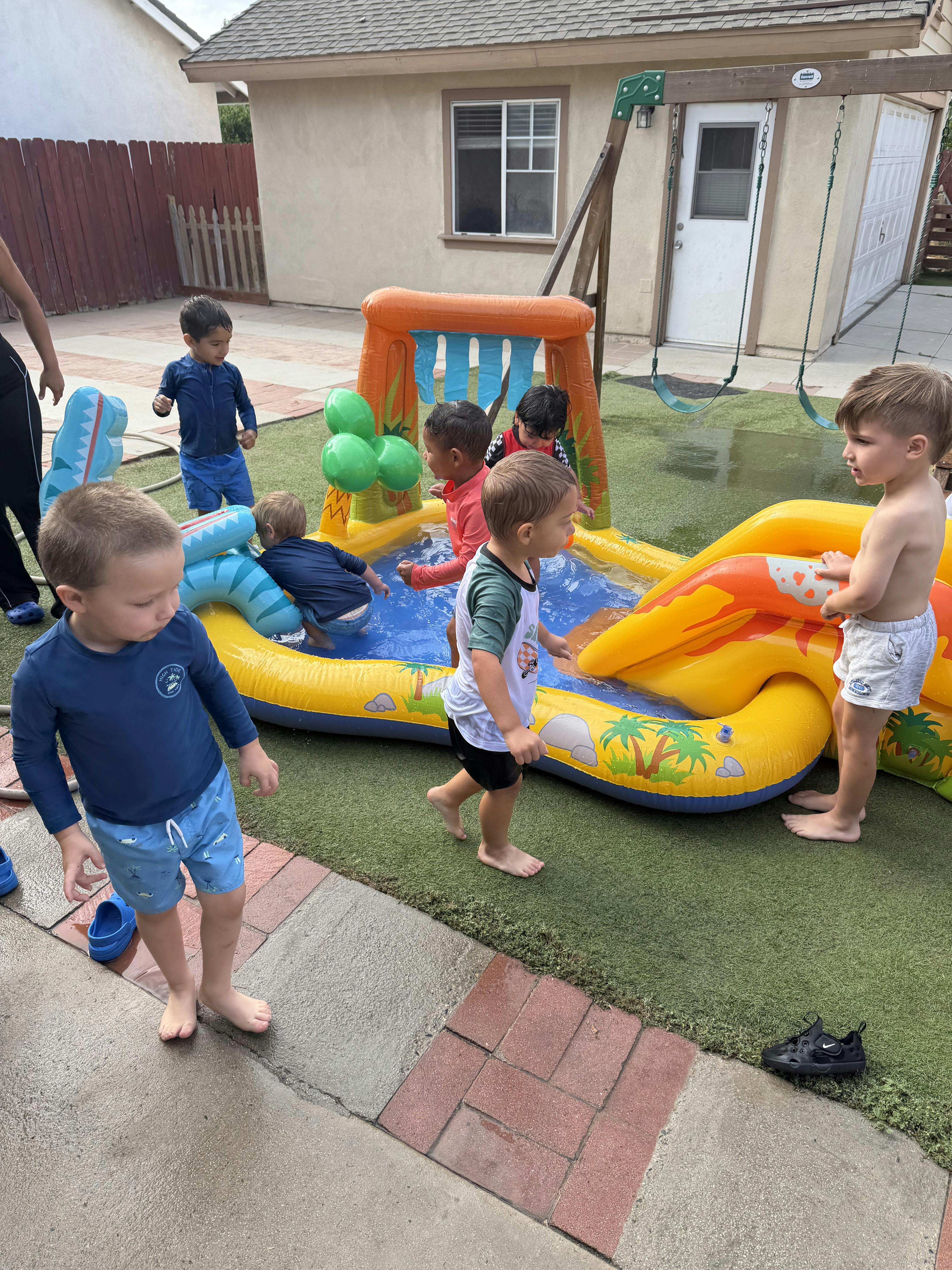 Children playing in an inflatable pool in a backyard