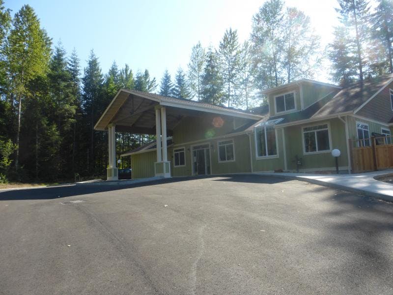 Building with covered entrance and trees in background