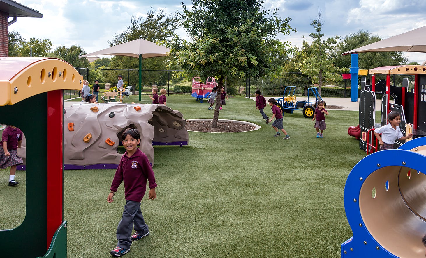 Children playing on a playground with artificial turf