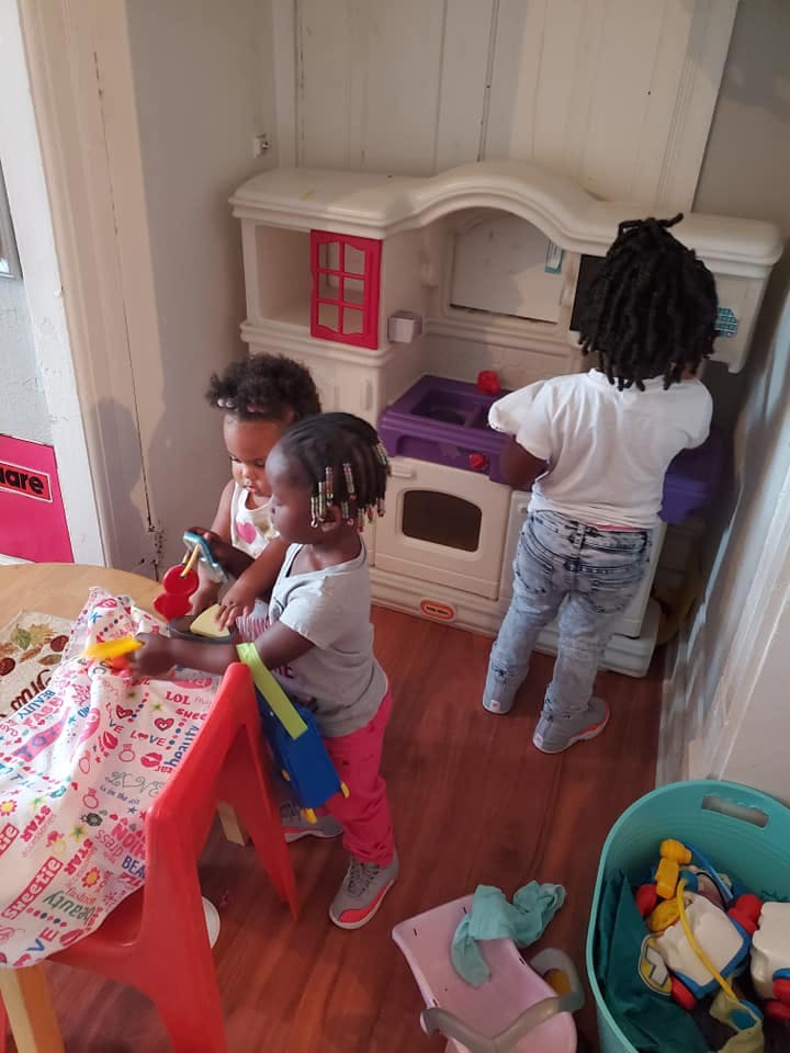 Three children playing with toys in a room