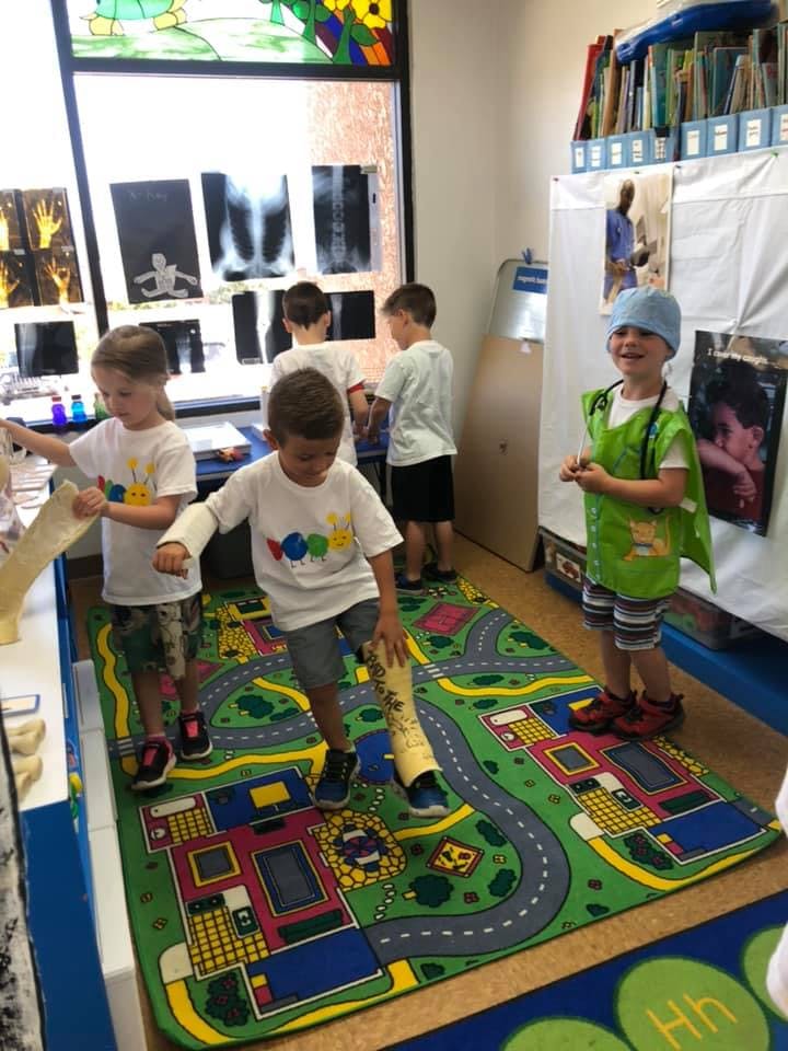 Children playing in a classroom with a road map rug