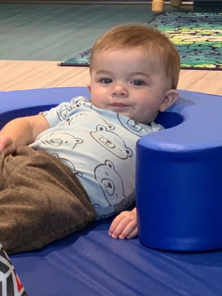 Child sitting in a blue support seat