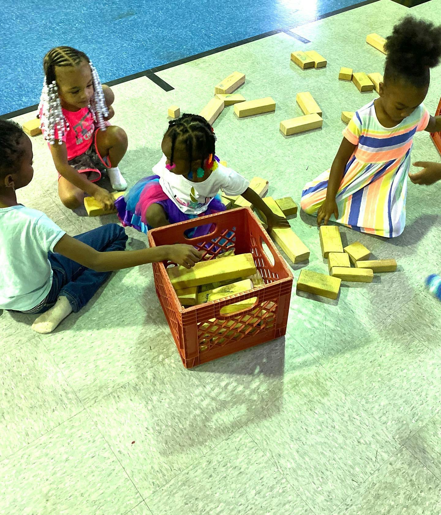 Children playing with wooden blocks on the floor