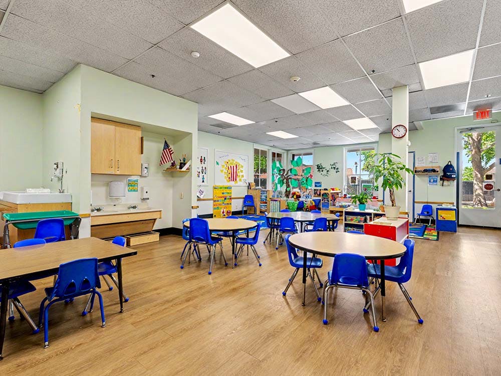 Empty classroom with small tables and blue chairs