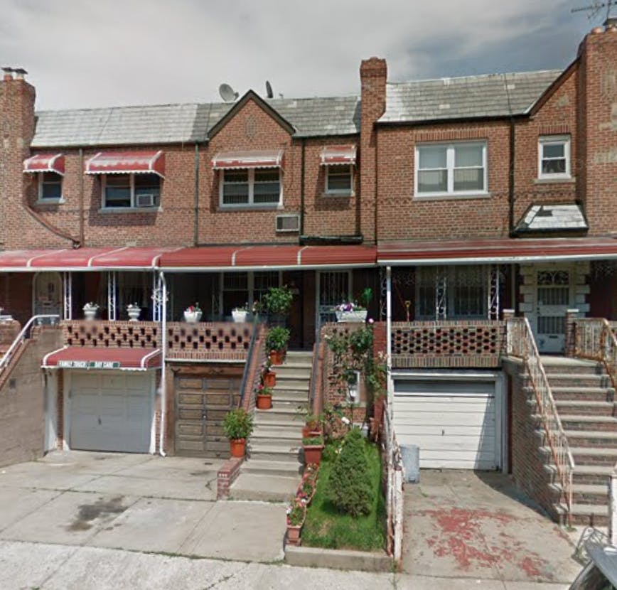 Row of brick houses with red awnings and front stairs leading to entrances