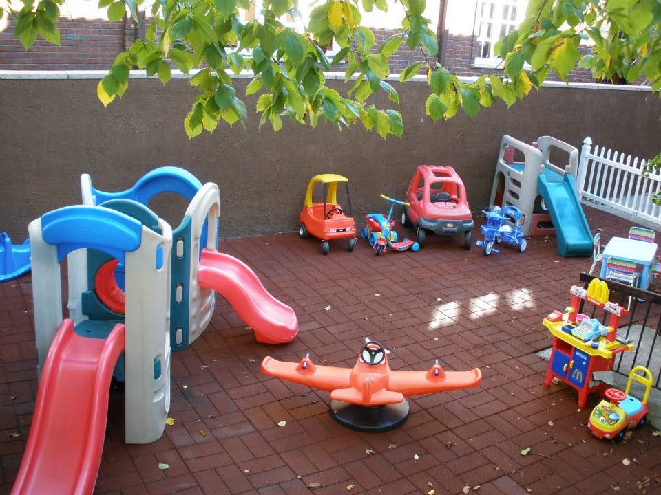 Outdoor playground with slides, ride-on toys, and a seesaw