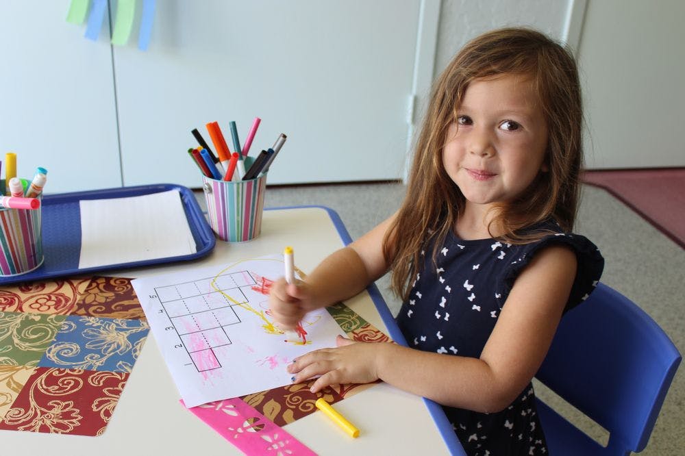Child coloring at a table