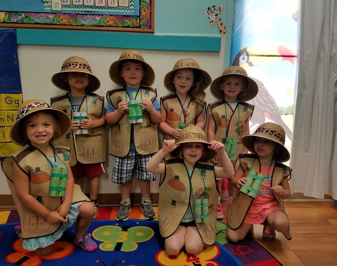 Group of children in explorer outfits with hats and binoculars