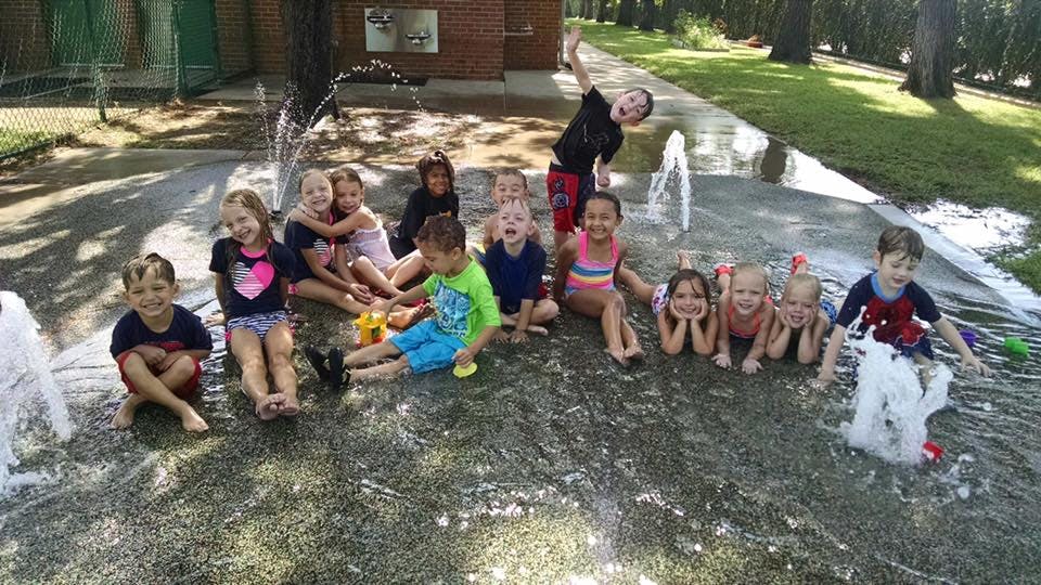 Group of children playing in a water fountain