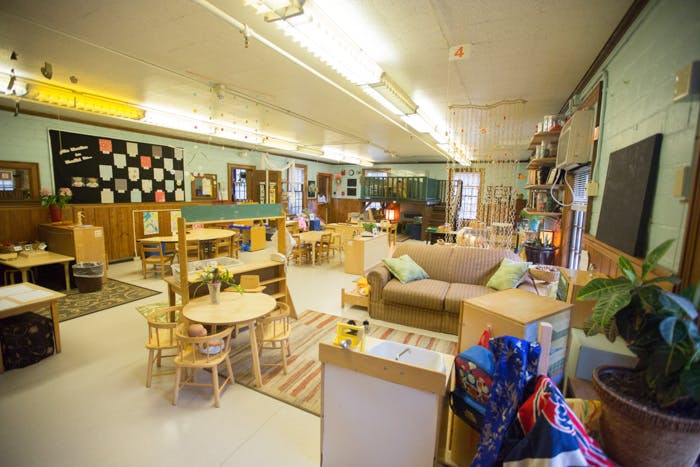 Classroom with small tables and chairs, a couch, and various learning materials