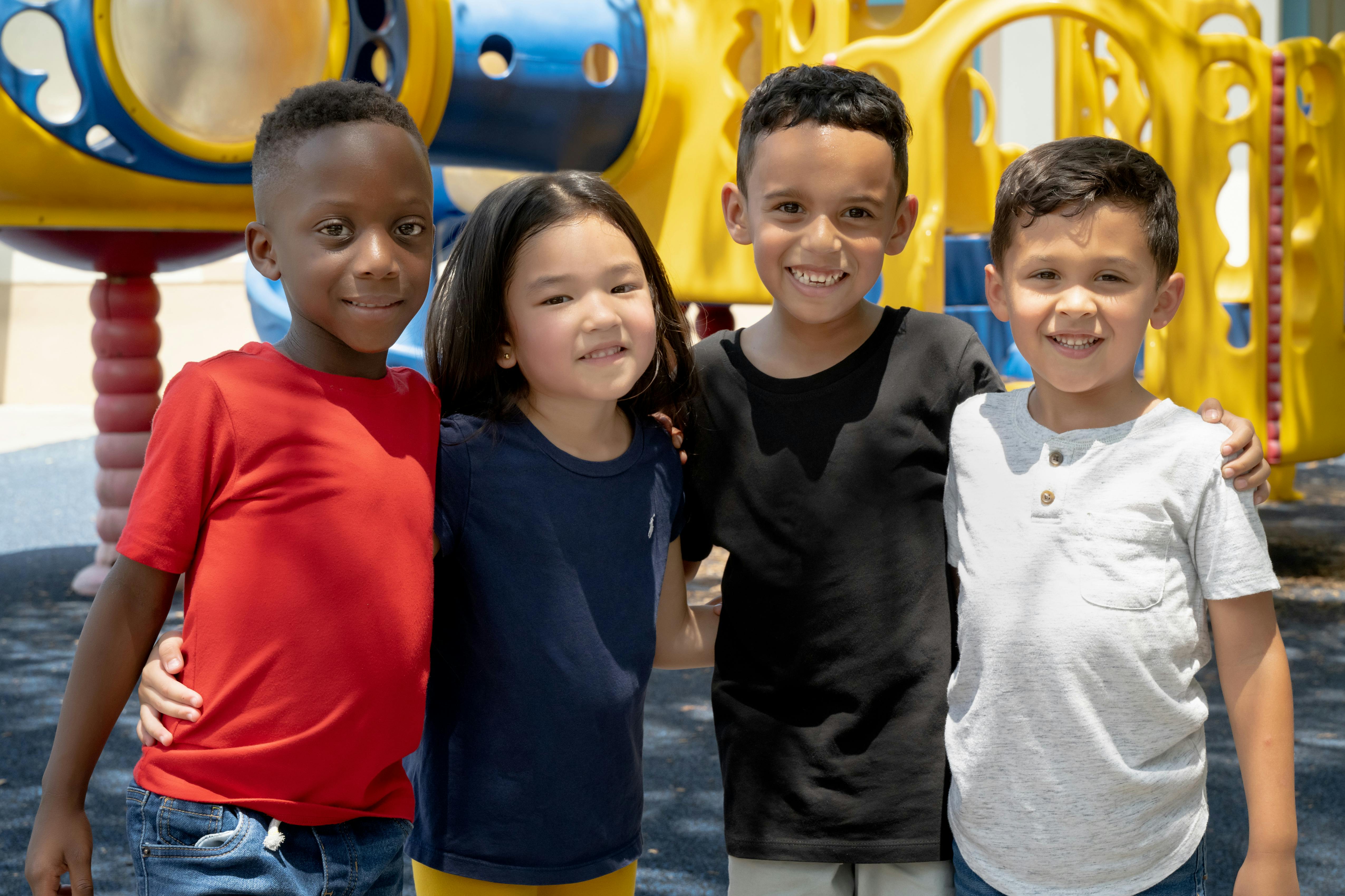 Four children standing together on a playground