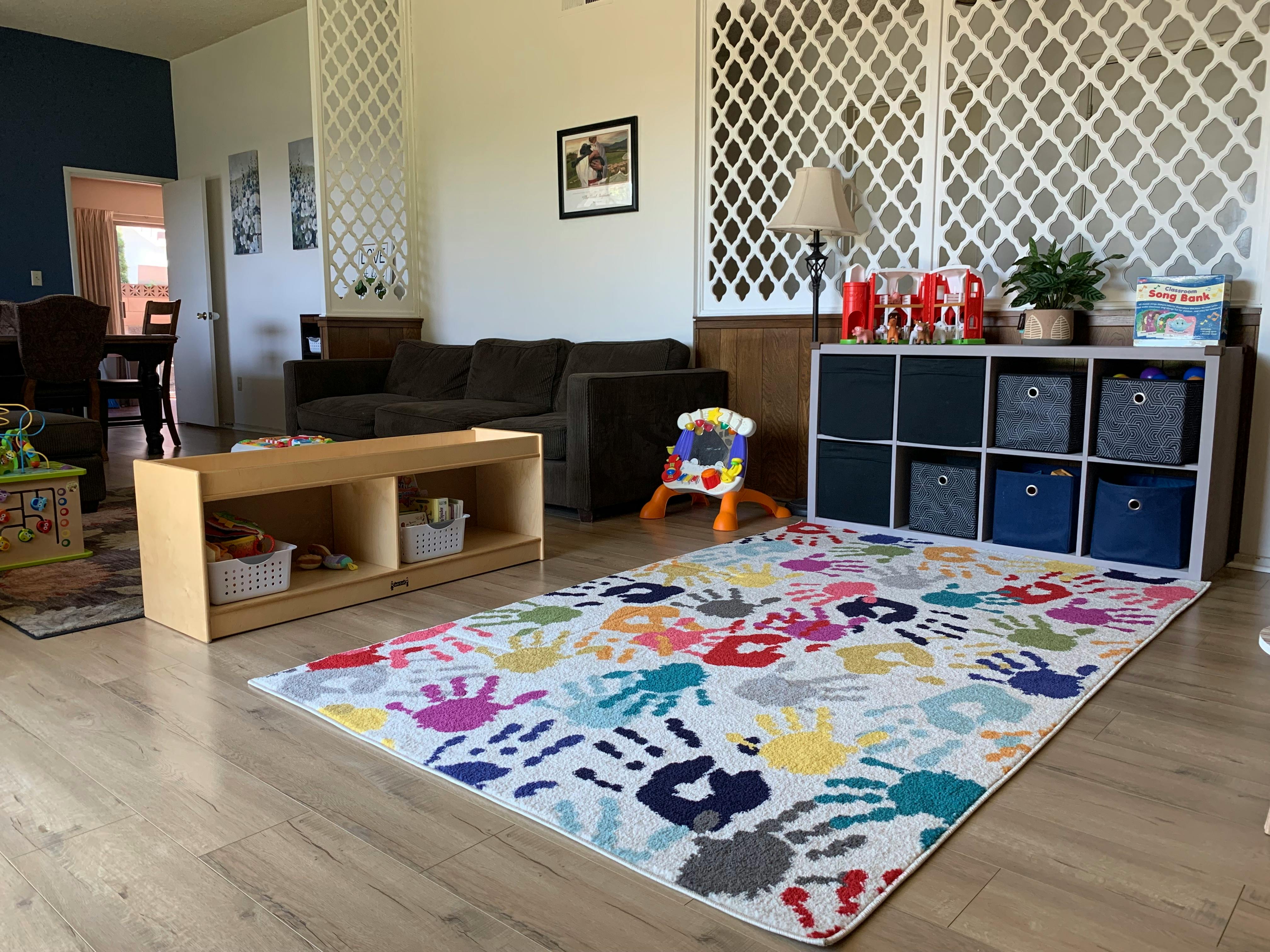 Living room with a colorful handprint rug and storage shelves