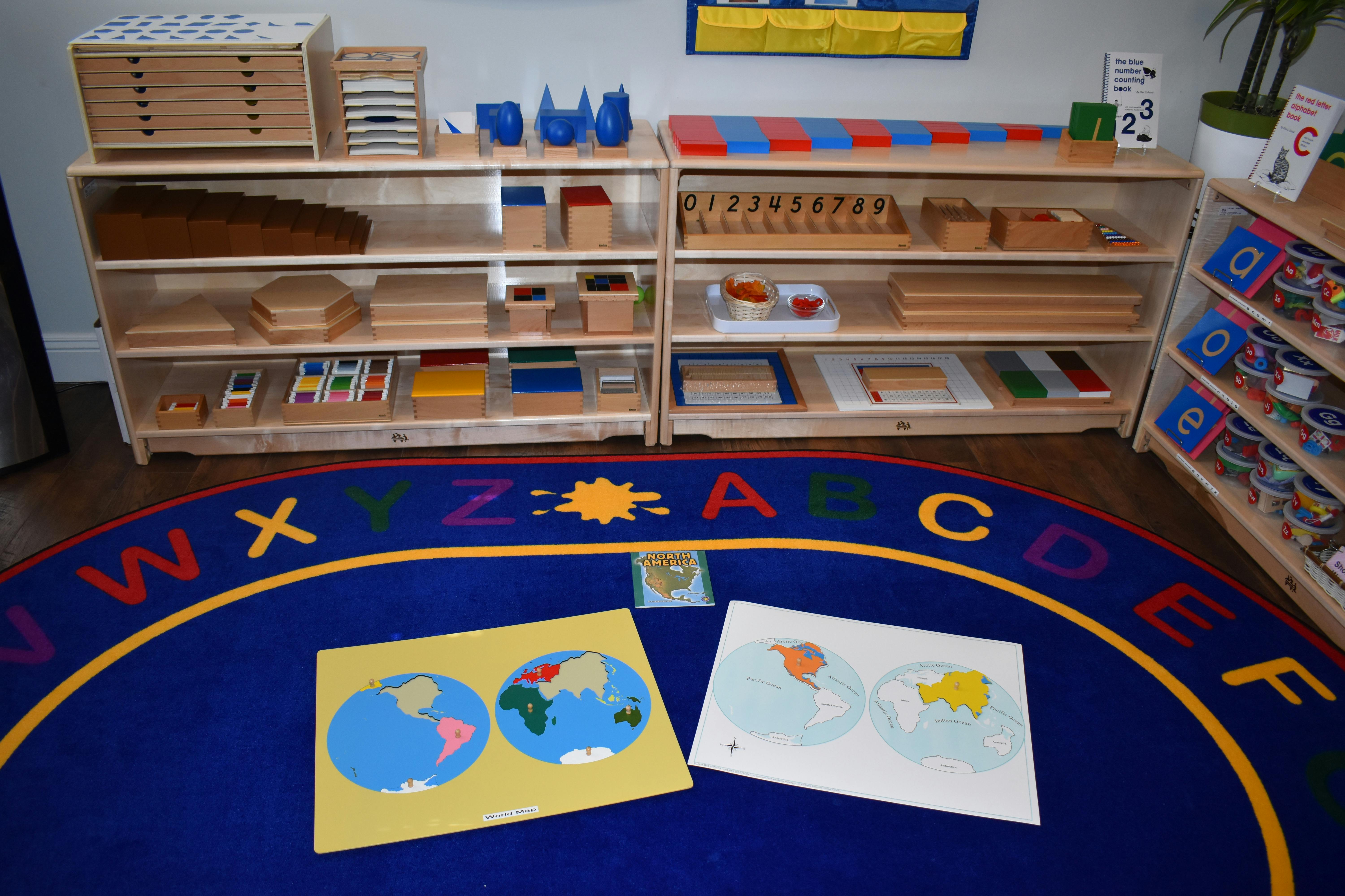 Classroom with shelves of learning materials and an alphabet rug