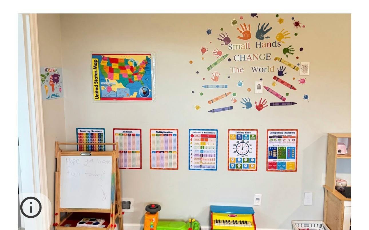 Classroom wall decorated with educational posters and a Small Hands Change the World decal
