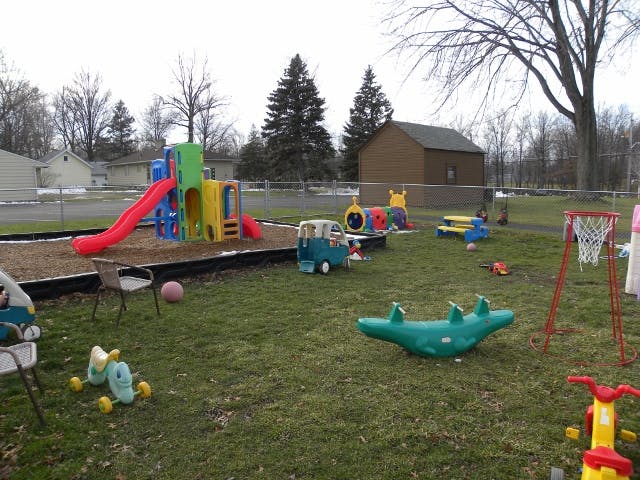 Outdoor playground with slides, swings, and various toys on grass