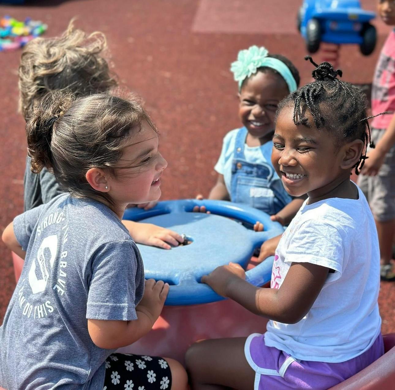 Children playing together on a blue outdoor toy