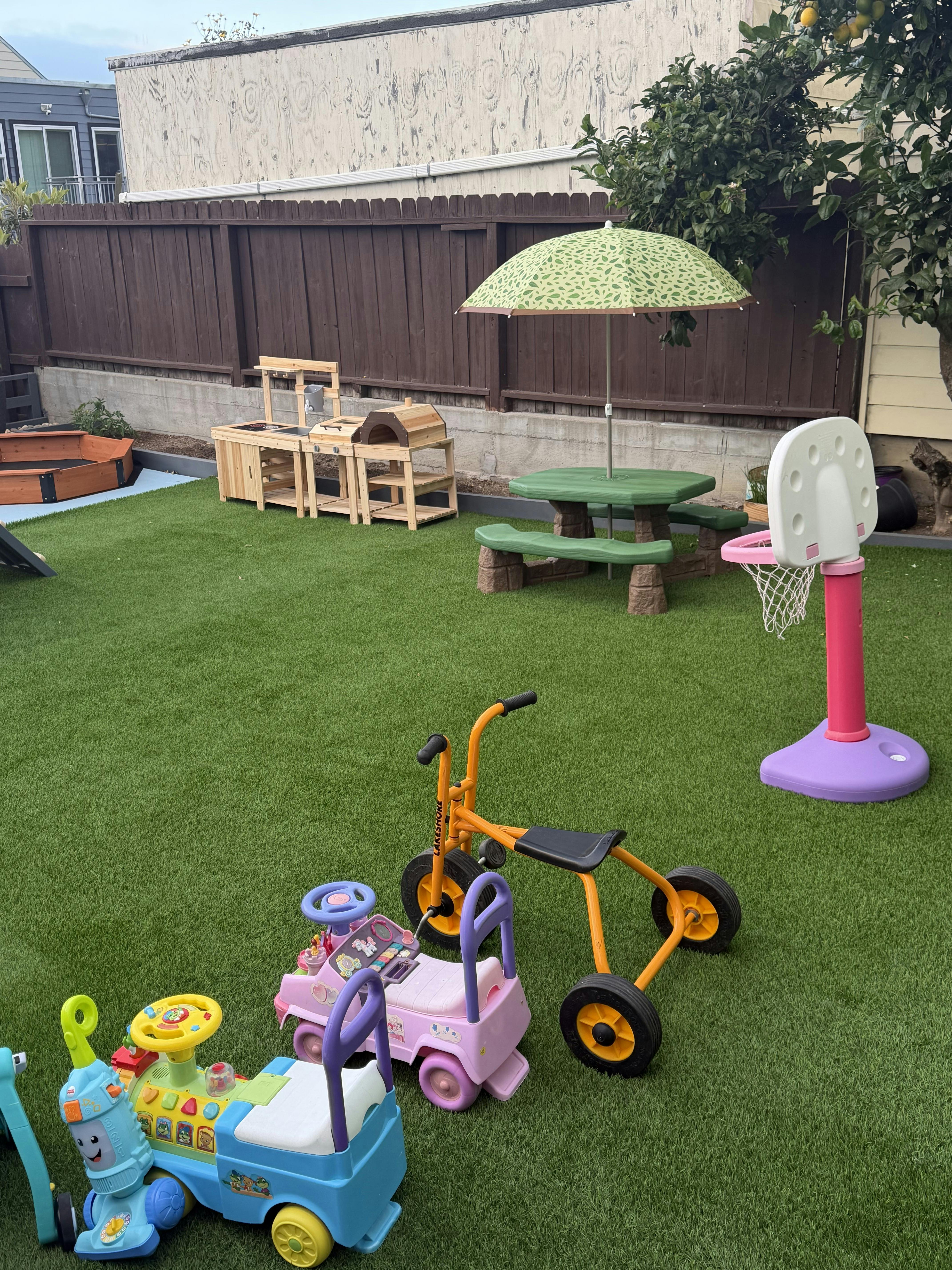 Children's outdoor play equipment and ride-on toys on a turf lawn