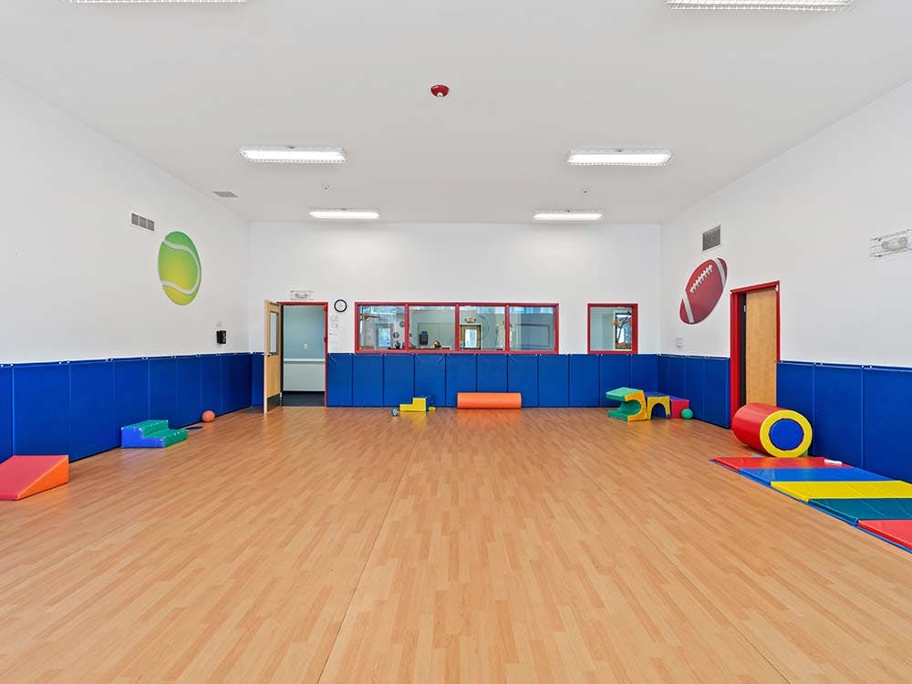Empty gym with soft play equipment and padded blue walls