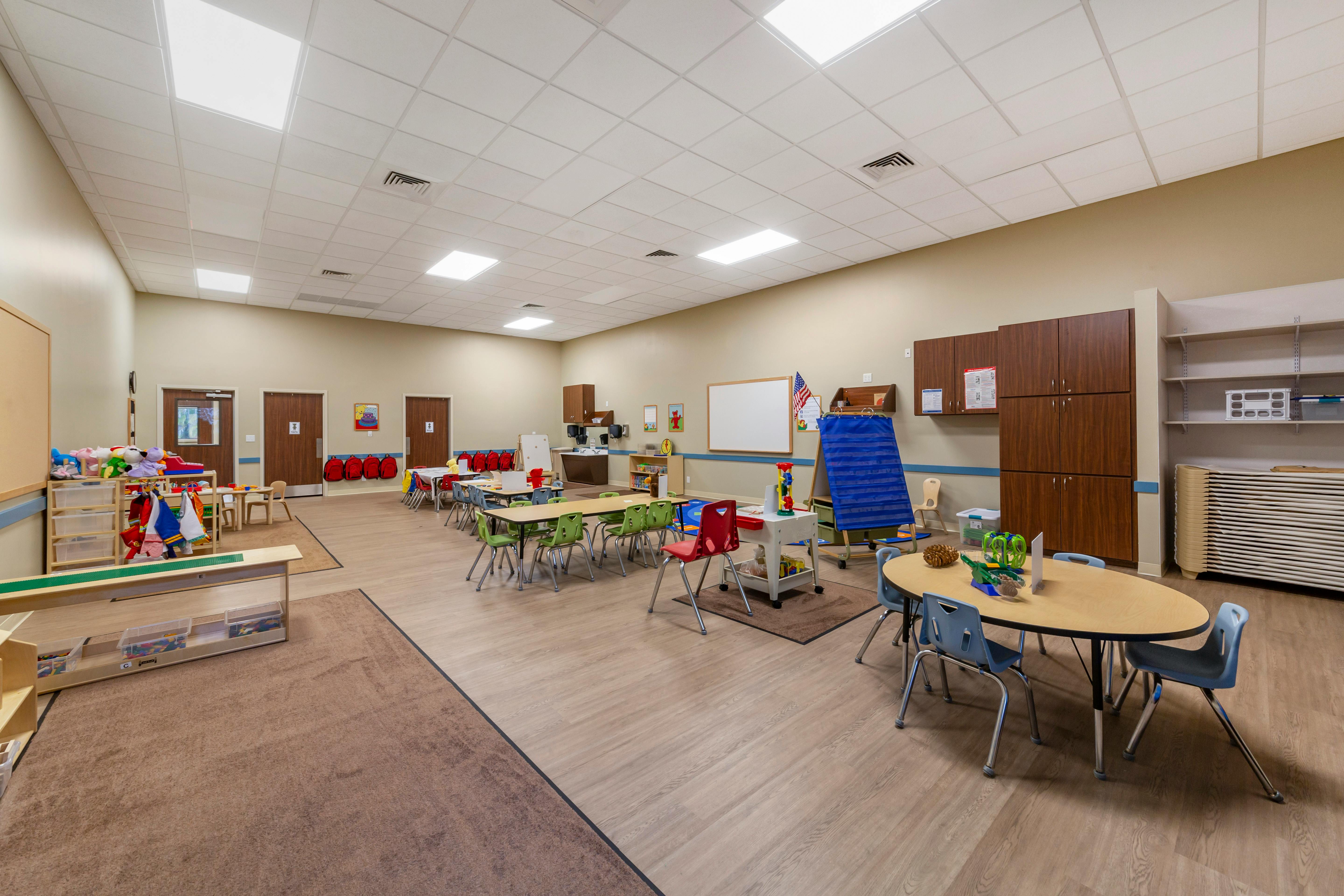 A colorful and spacious classroom with tables, chairs, and learning materials