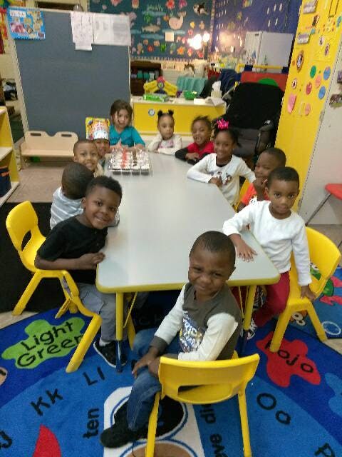 Group of children sitting around a table in a classroom