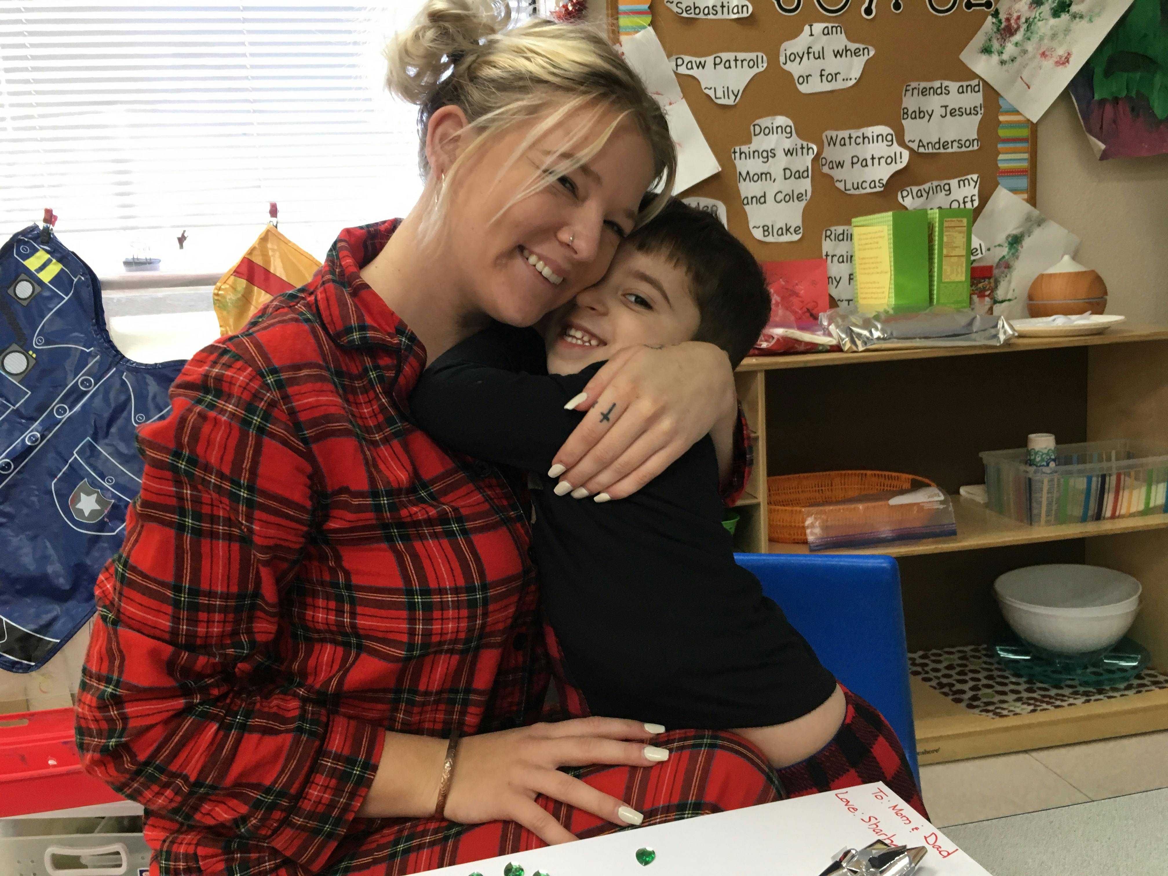 Person in plaid shirt hugging a child