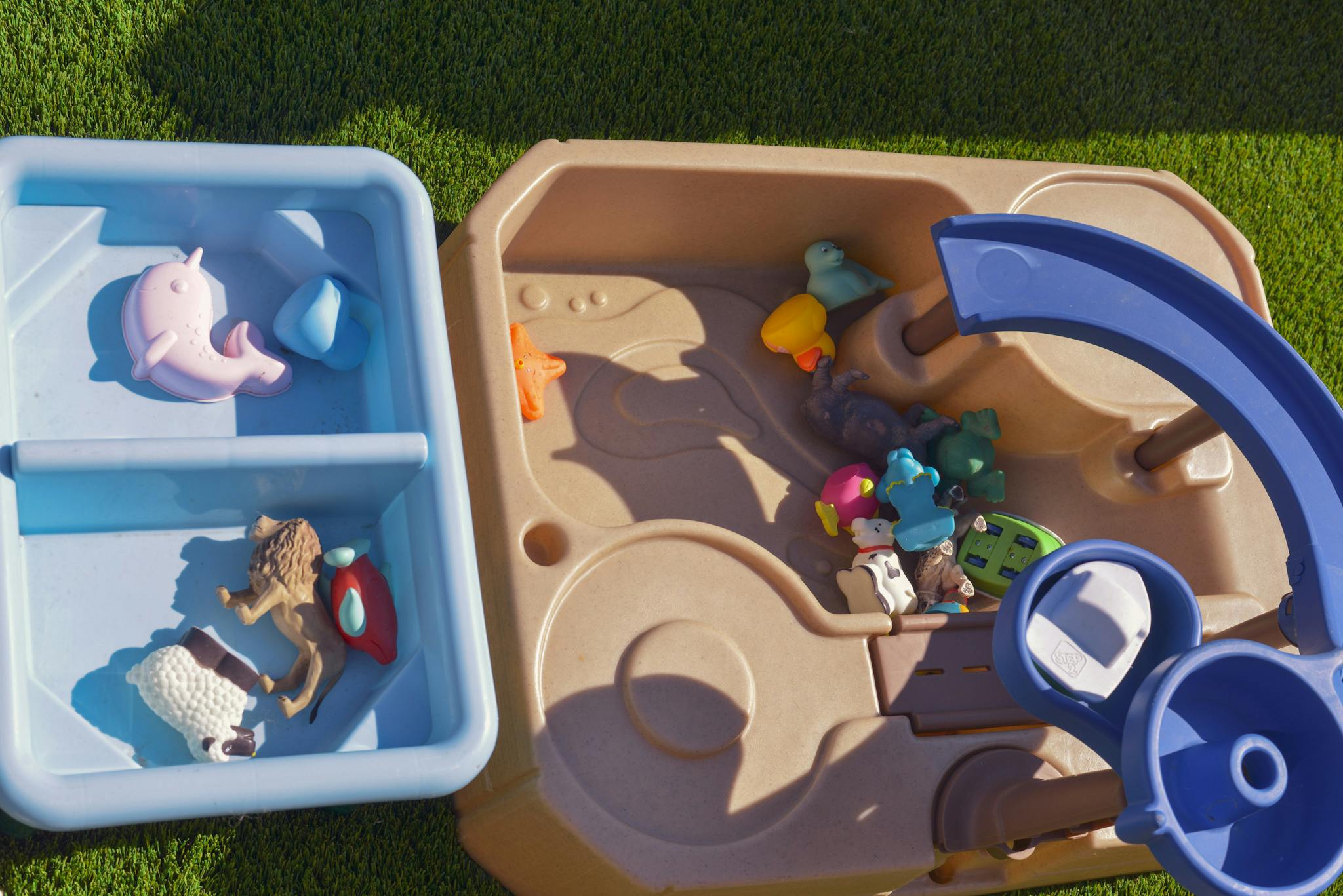 Water table with toys and a blue bin with toys