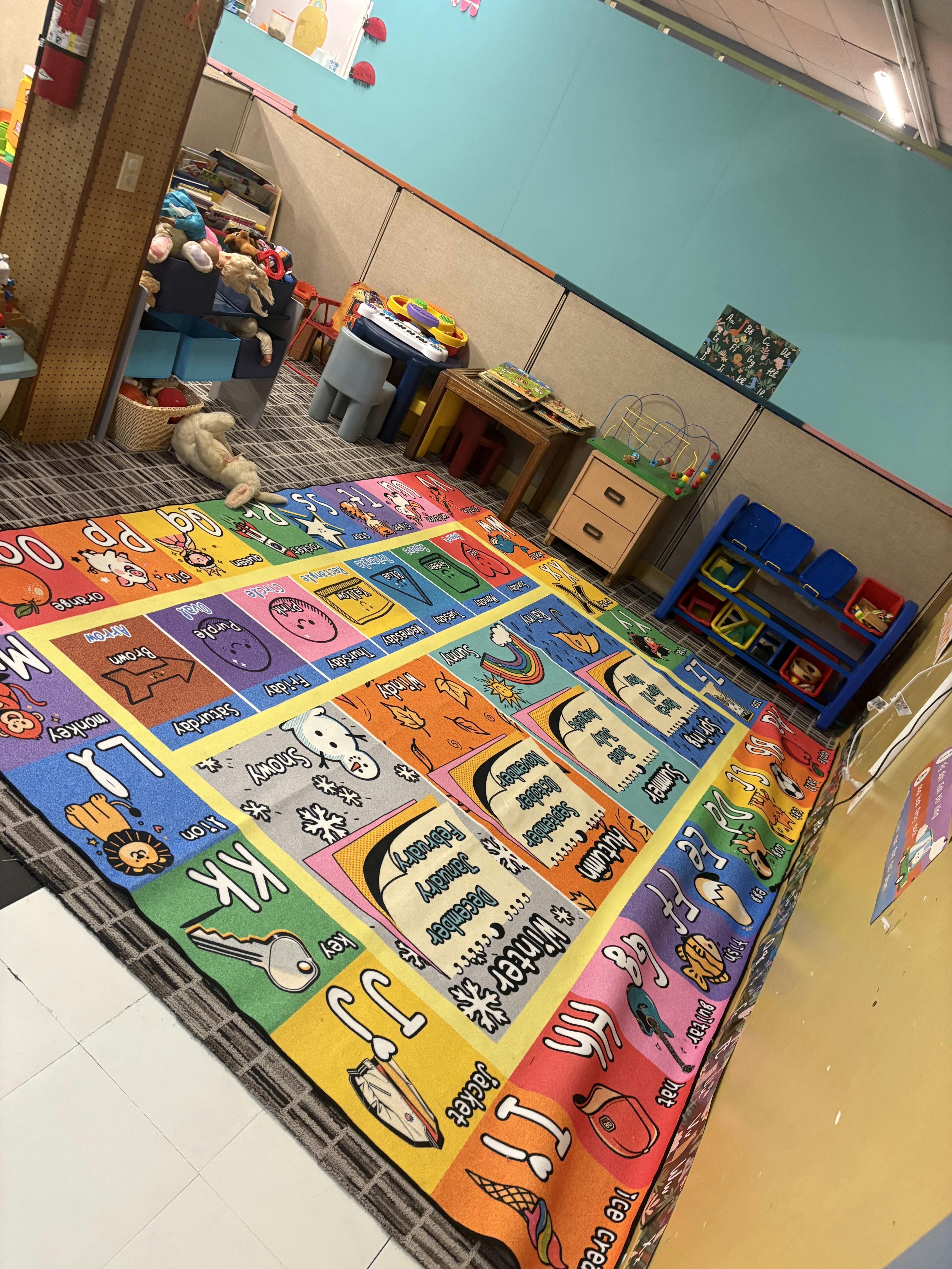Colorful educational carpet with alphabet letters and seasonal labels in classroom