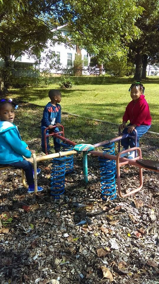 Three children on a playground seesaw