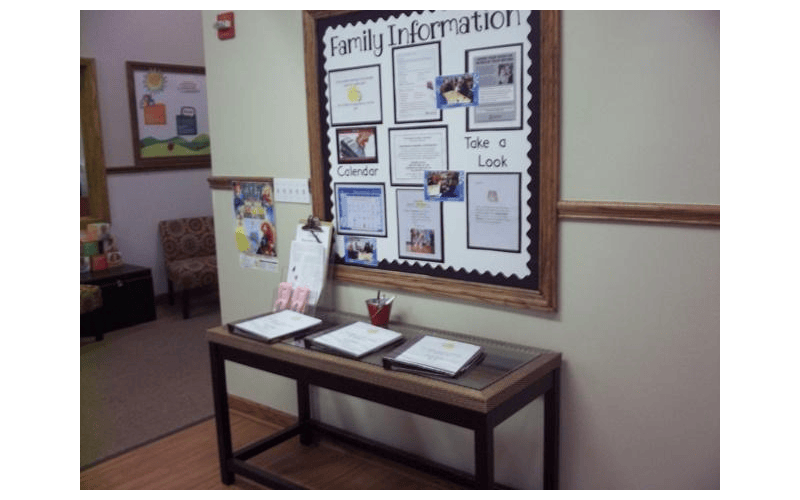 Family information bulletin board with papers and a table with folders below
