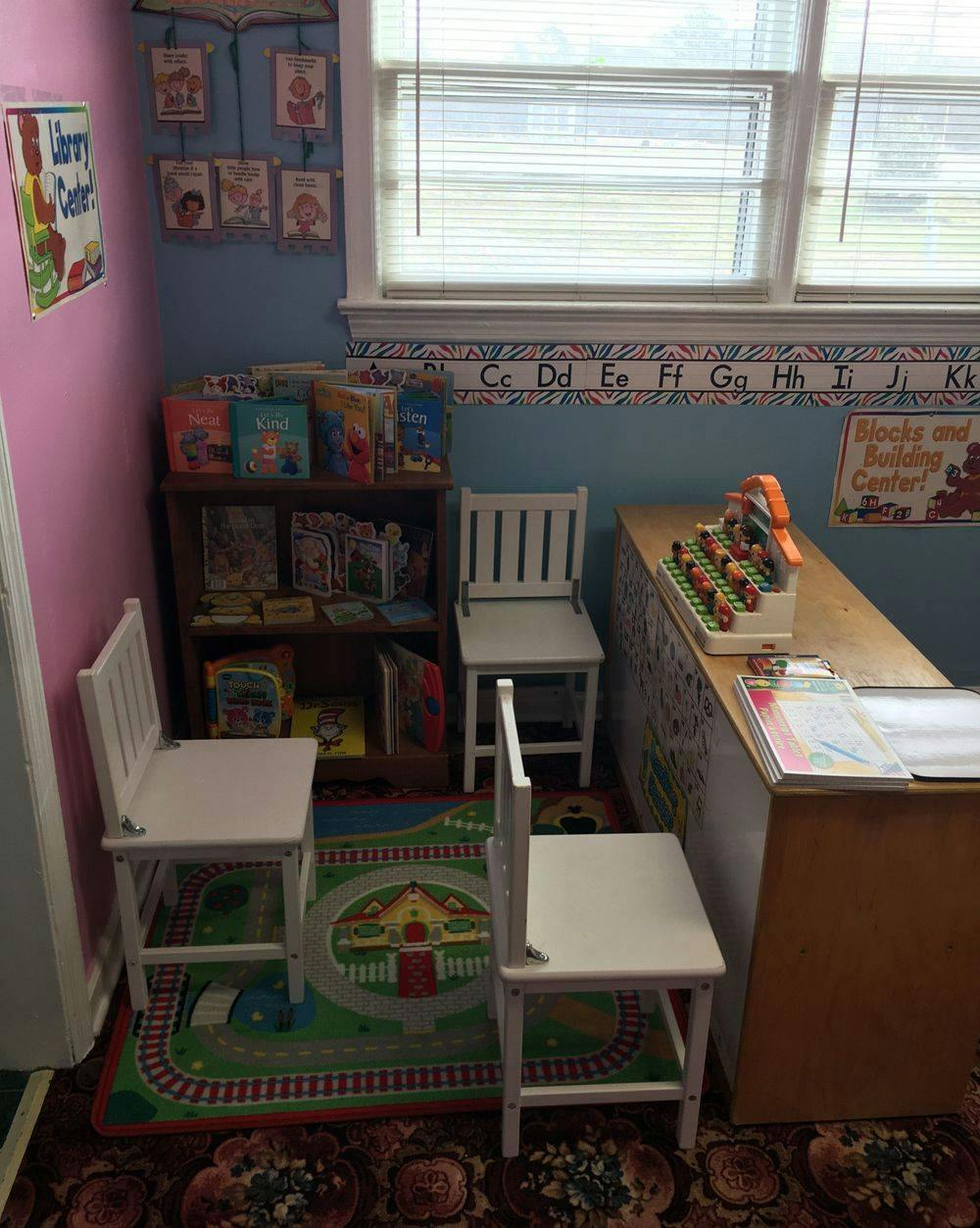 Children's library corner with small chairs, rug, and books