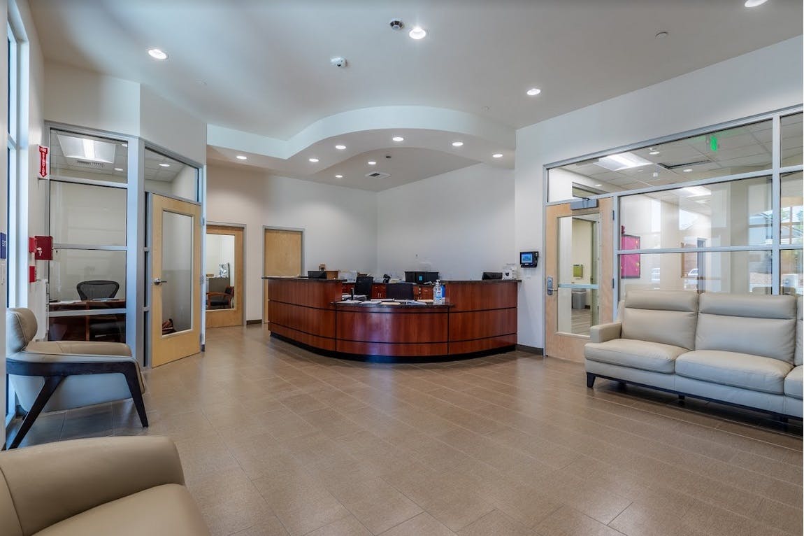 Lobby with a curved wooden reception desk and seating areas