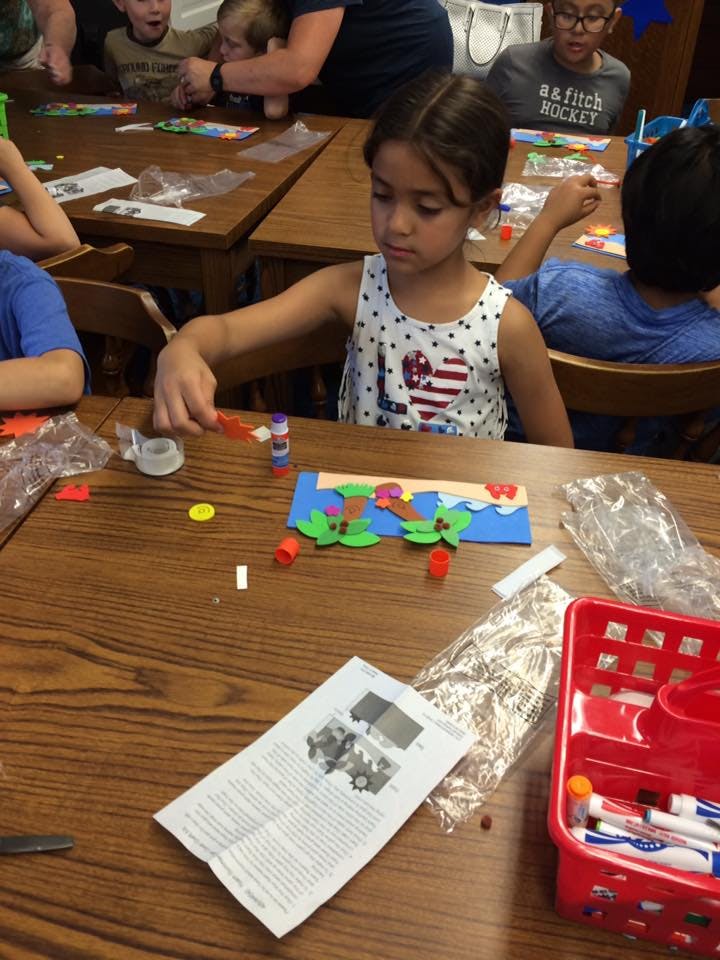 Child making a craft at a table