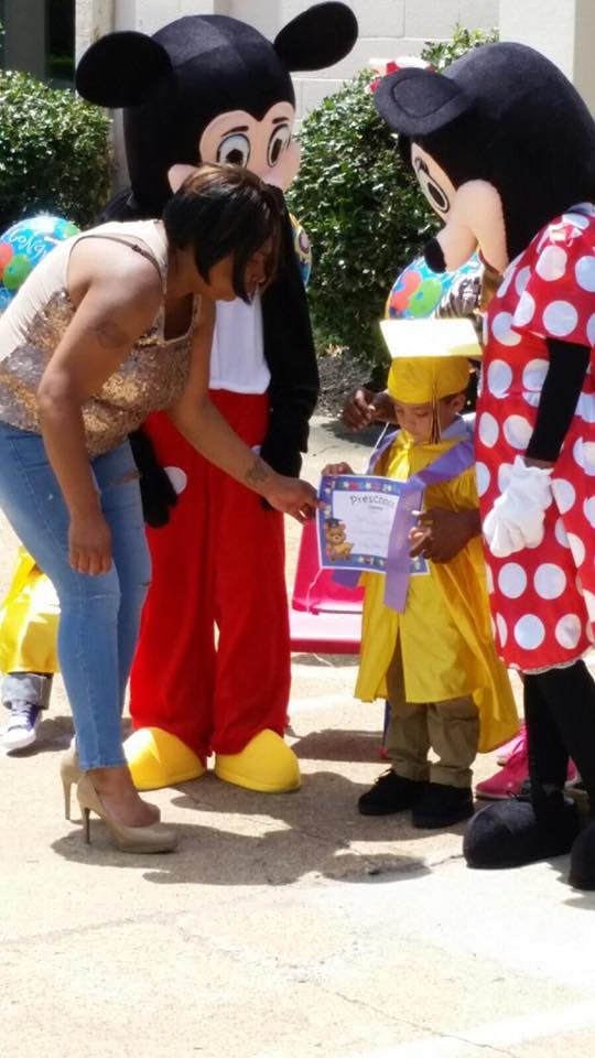 Person in Mickey Mouse costume and person in Minnie Mouse costume with a child
