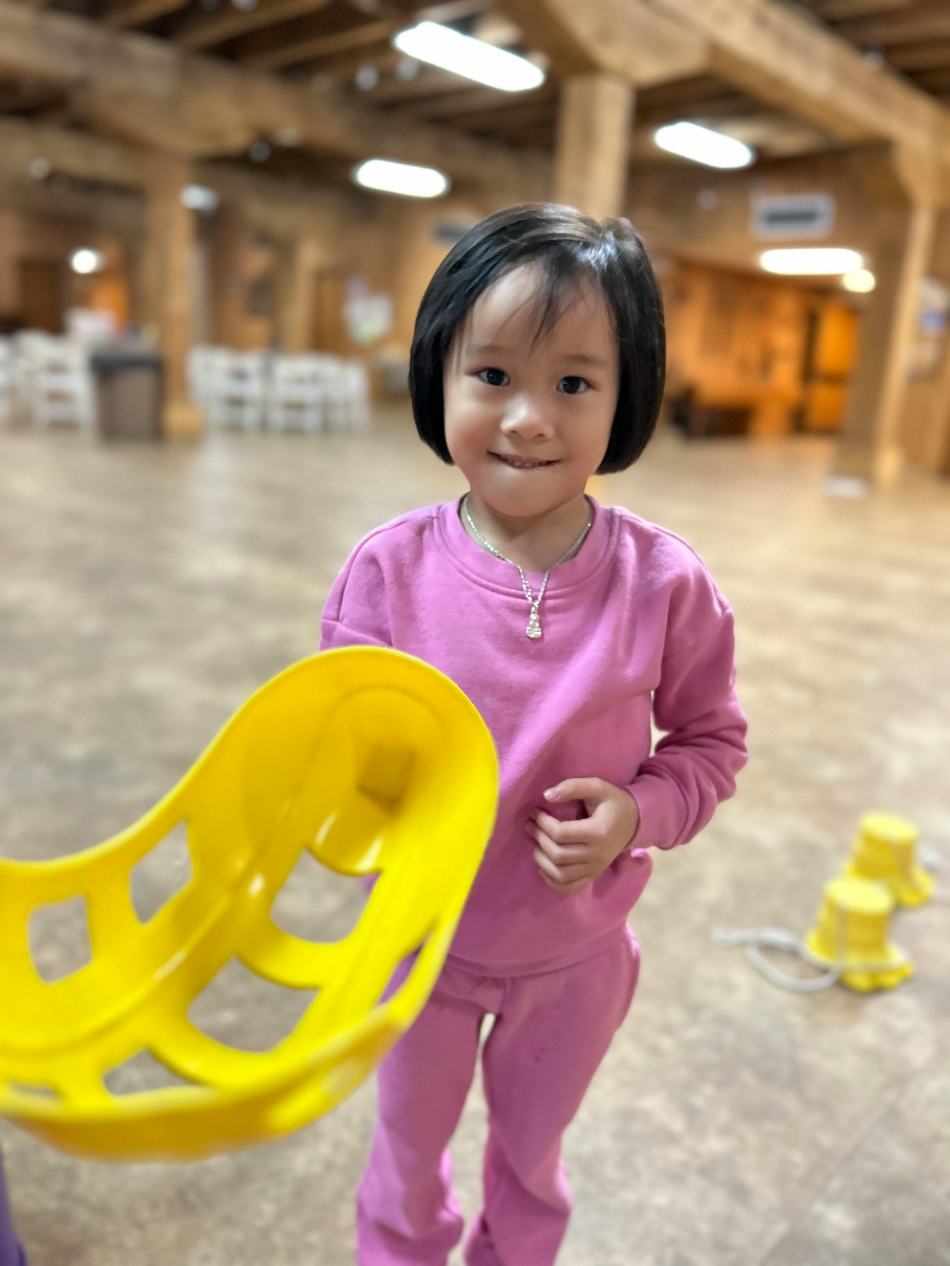 Child holding a yellow scoop toy