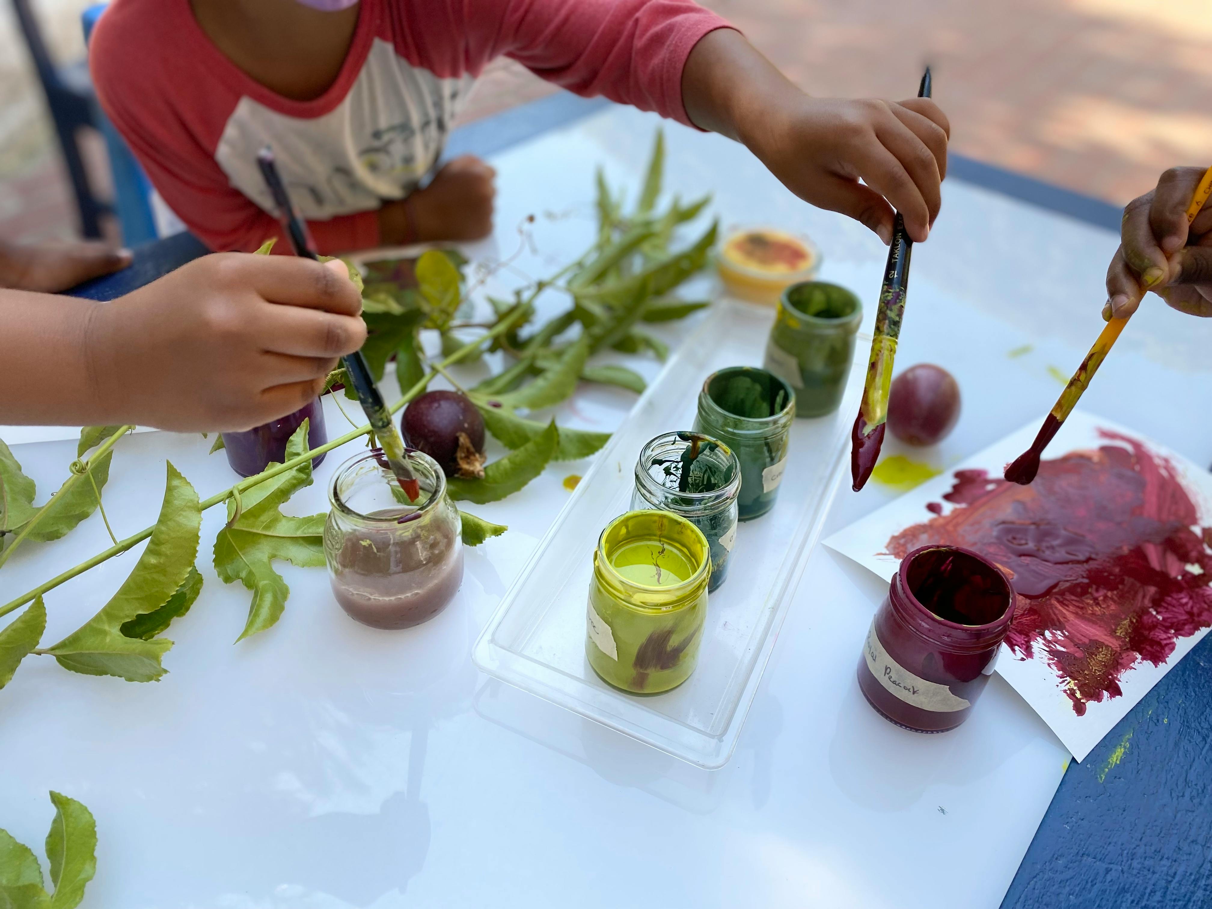People painting with natural dyes and brushes